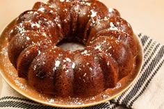 a bundt cake sitting on top of a white plate covered in powdered sugar