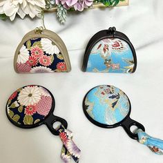 four flowered purses sitting on top of a white sheet