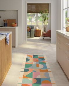 a colorful rug in the middle of a kitchen with lots of counter space and furniture