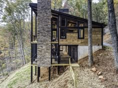 a house in the woods is made out of wood and stone, with stairs leading up to it