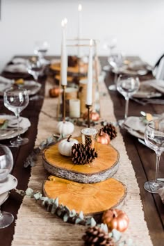 a wooden table topped with plates and candles