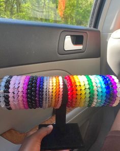 a person holding up a bunch of bracelets in their car