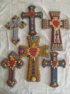 some very pretty decorated crosses on a white sheet