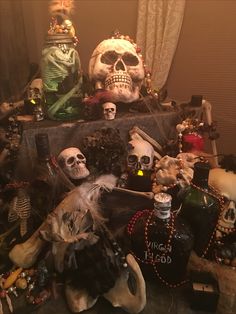 a pile of halloween decorations with skulls and bottles on the table in front of them