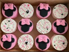 twelve cupcakes in a box decorated with pink and white frosting minnie mouse ears