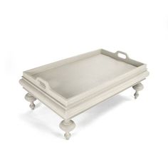 a white tray with two legs and an oval handle on the bottom is shown in front of a white background