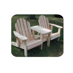 two wooden chairs sitting on top of a lush green field