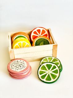 four slices of fruit in a wooden box on a white surface with one cut open and the other sliced