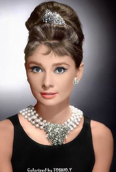 a barbie doll wearing a black dress with pearls on it's head and necklace