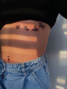 a woman's stomach with butterflies on it and the bottom part of her belly