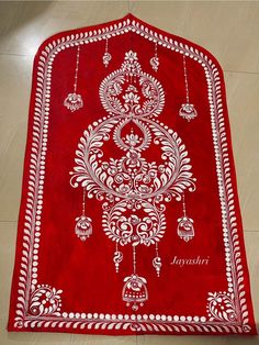 a red and white rug on the floor with an ornate design in it's center