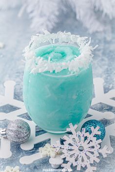 there is a frosted drink on the table with snowflakes and ornaments around it