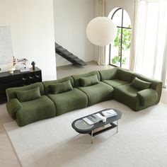 a living room with a large green sectional couch