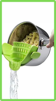 a person is pouring pasta into a colander with the lid open and it's green