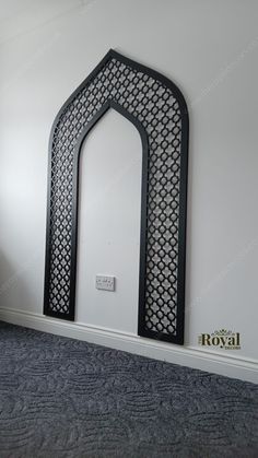 an arch in the corner of a room with carpet on the floor and wall behind it