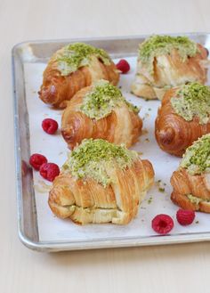 several croissants with pesto and raspberries on top