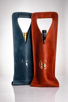 two leather wine bags one has a bottle in it and the other has a lighter