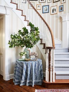 a table with a potted plant on it in front of a stair case next to a set of stairs