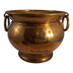 an antique brass urn with handles is shown on a white background for use as a centerpiece