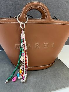 a handbag with beads hanging from it's handle