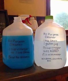 two plastic jugs sitting on top of a counter with writing on the side of them