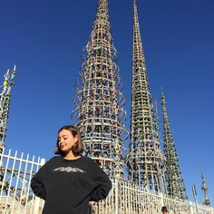 a woman standing in front of a very tall building with lots of wires attached to it