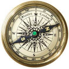 an old brass compass with the needle pointing in to it's center, on a white