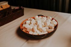 a bowl filled with marshmallows sitting on top of a table