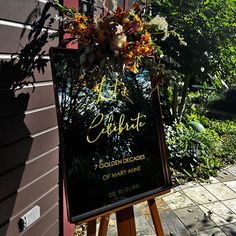 a sign with flowers on it in front of a building