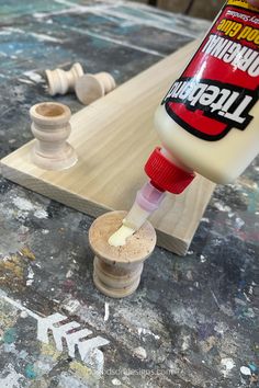 a bottle of glue is being used to paint the top of a piece of wood