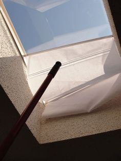 a baseball bat laying on the ground in front of a window with skylights above it