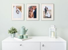 a white dresser topped with pictures next to a vase filled with flowers and a tea pot