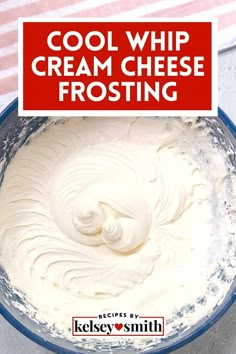 a blue bowl filled with cream cheese frosting on top of a white and red striped towel