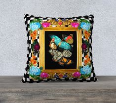 a black and white pillow with colorful flowers on the front, sitting on a wooden table