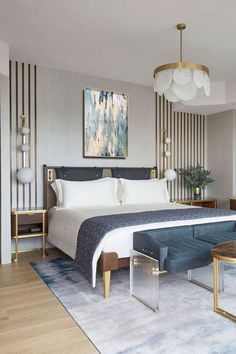 a bedroom with a large bed, blue couch and gold accents on the headboard