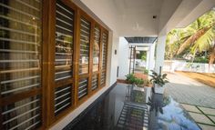 an outside view of a house with large windows and plants on the front porch area