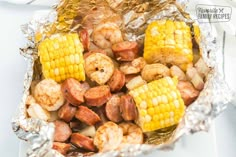 shrimp and corn on the cob wrapped in aluminum foil with text overlay that reads,