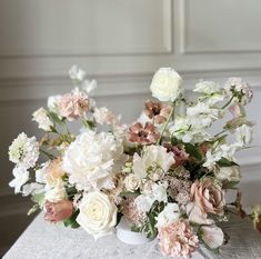 a vase filled with lots of white and pink flowers