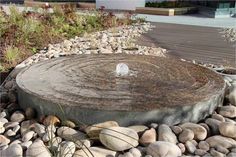 a water fountain surrounded by rocks and plants