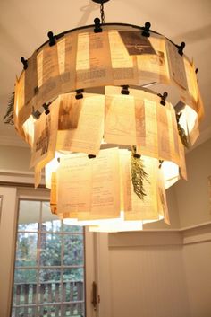 a chandelier made out of old book pages hanging from the ceiling in a room