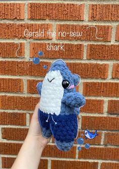 someone is holding up a crocheted blue and white stuffed animal that says, gerald the no - sevy shark