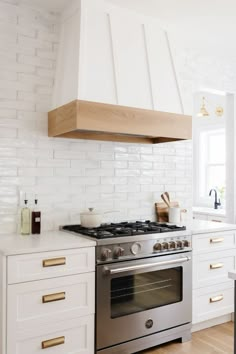 a stove top oven sitting inside of a kitchen next to white cabinets and counter tops