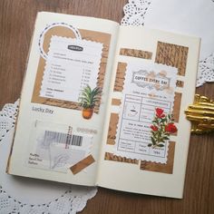 an open book with flowers on it sitting on top of a doily covered table