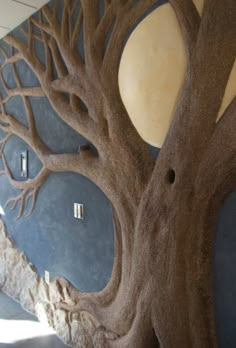 a large tree sculpture in front of a wall