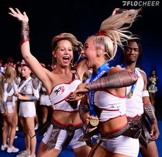 two women in white and red cheer as they dance