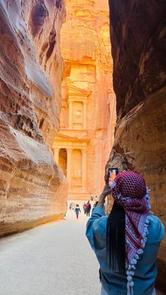 a woman taking a photo in the narrow canyon