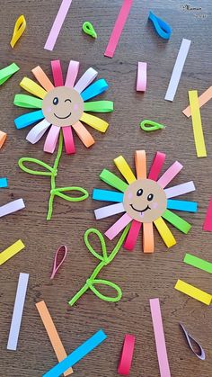 paper flowers and scissors are on the table with colored stick art pieces in front of them