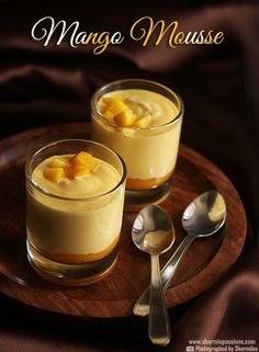 two glasses of mango mousse on a wooden plate