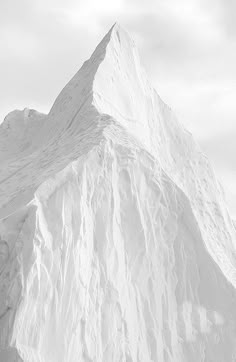 a man riding skis down the side of a snow covered slope in front of a mountain