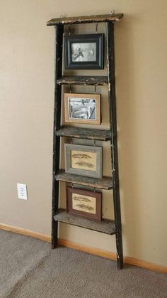 an old ladder leaning up against the wall with pictures on it and framed photos below